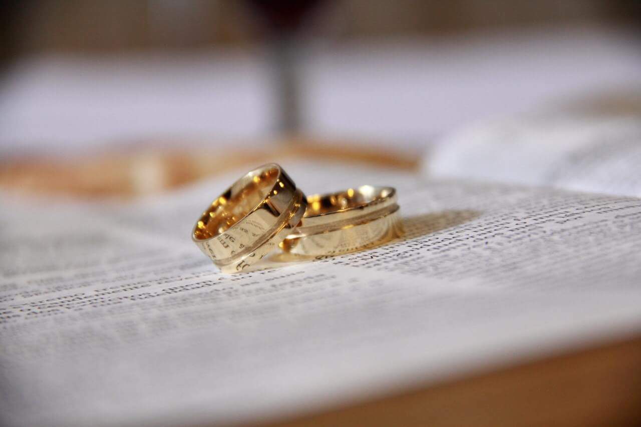2 yellow gold rings on a book