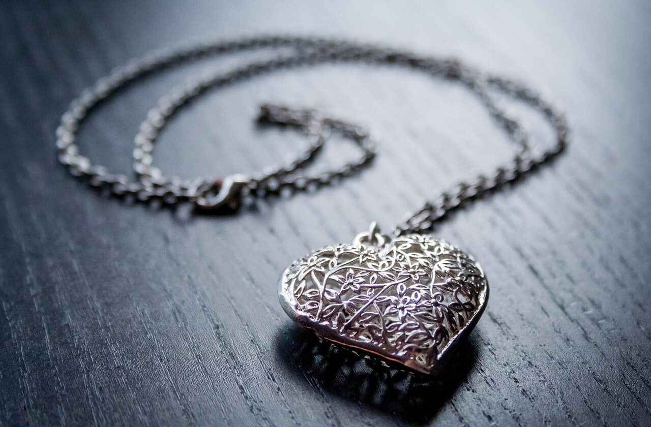 heart shaped sterling silver necklace on wooden surface