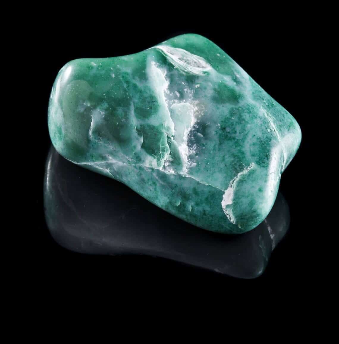Jadeite mineral stone close up with reflection on black surface Jewelry Guide