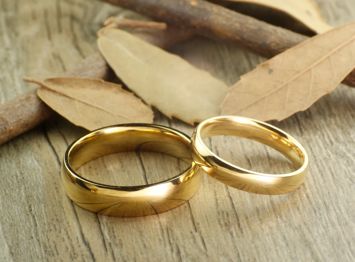two wedding rings on wood setting