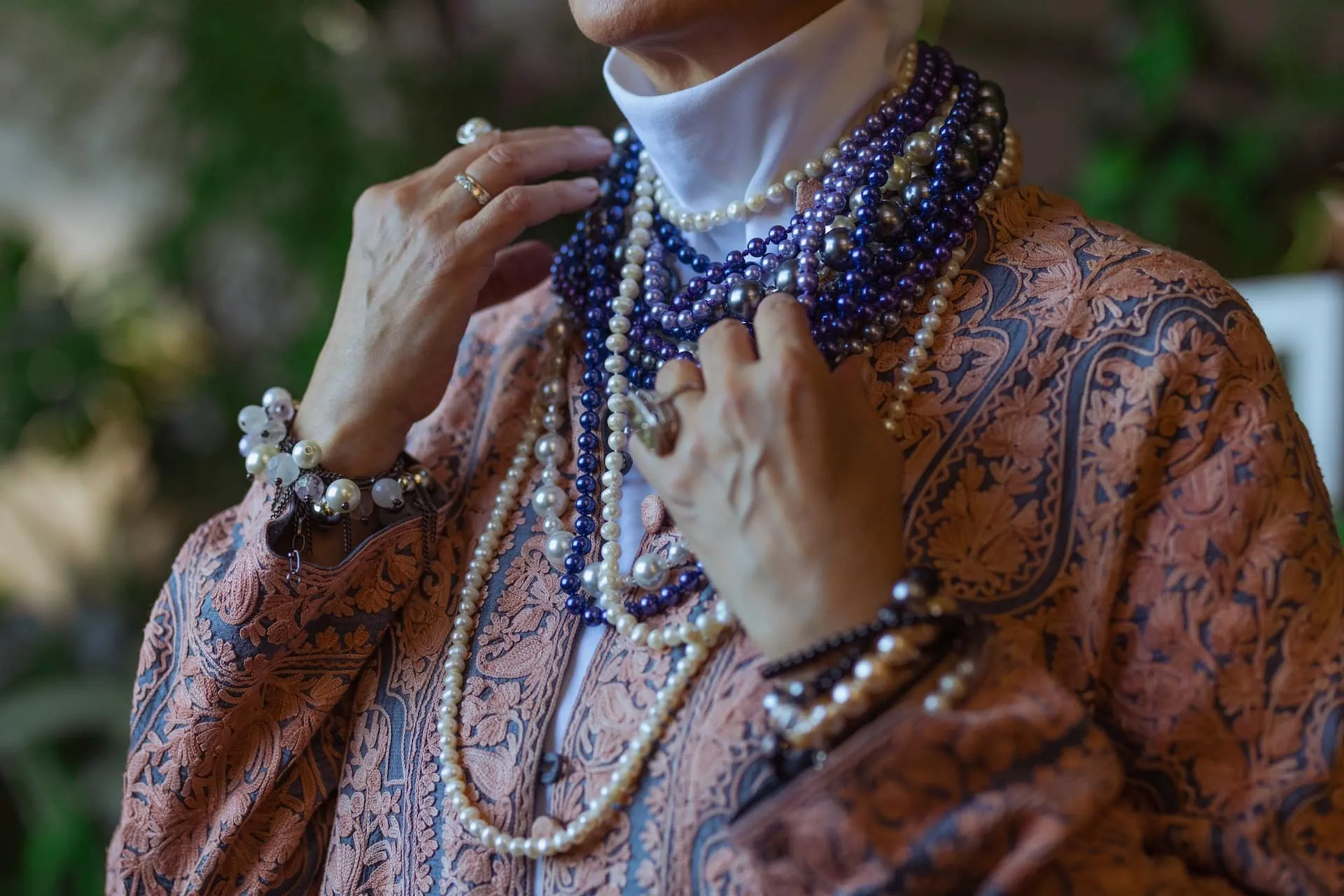 woman wearing strands of colored pearls