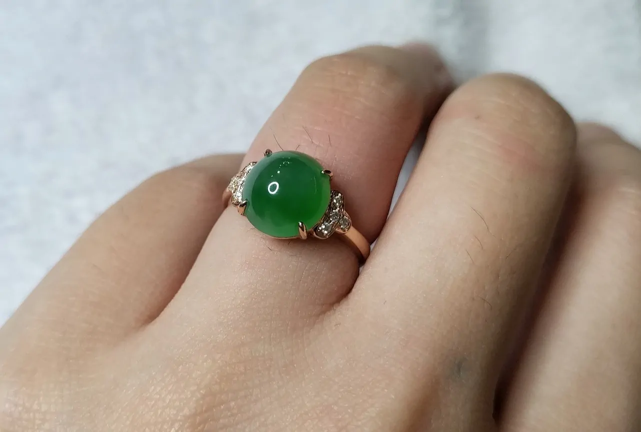 jade ring in gold setting on womans hand