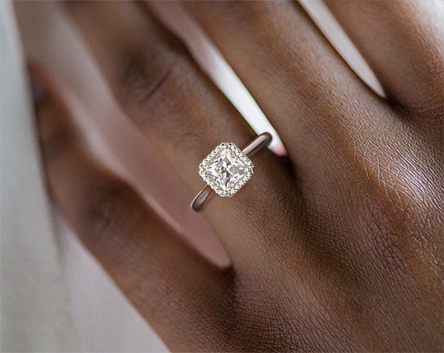 Low color grade diamond engagement ring in finger dark skin