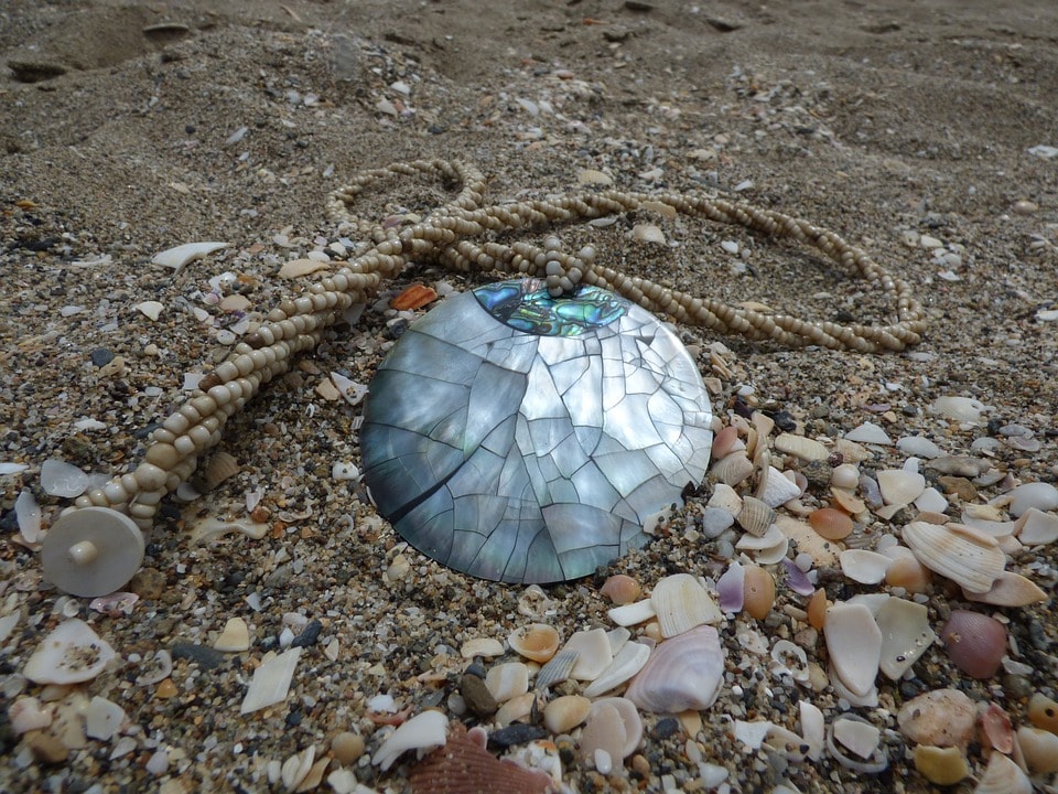 Mother of pearl pendant on beach