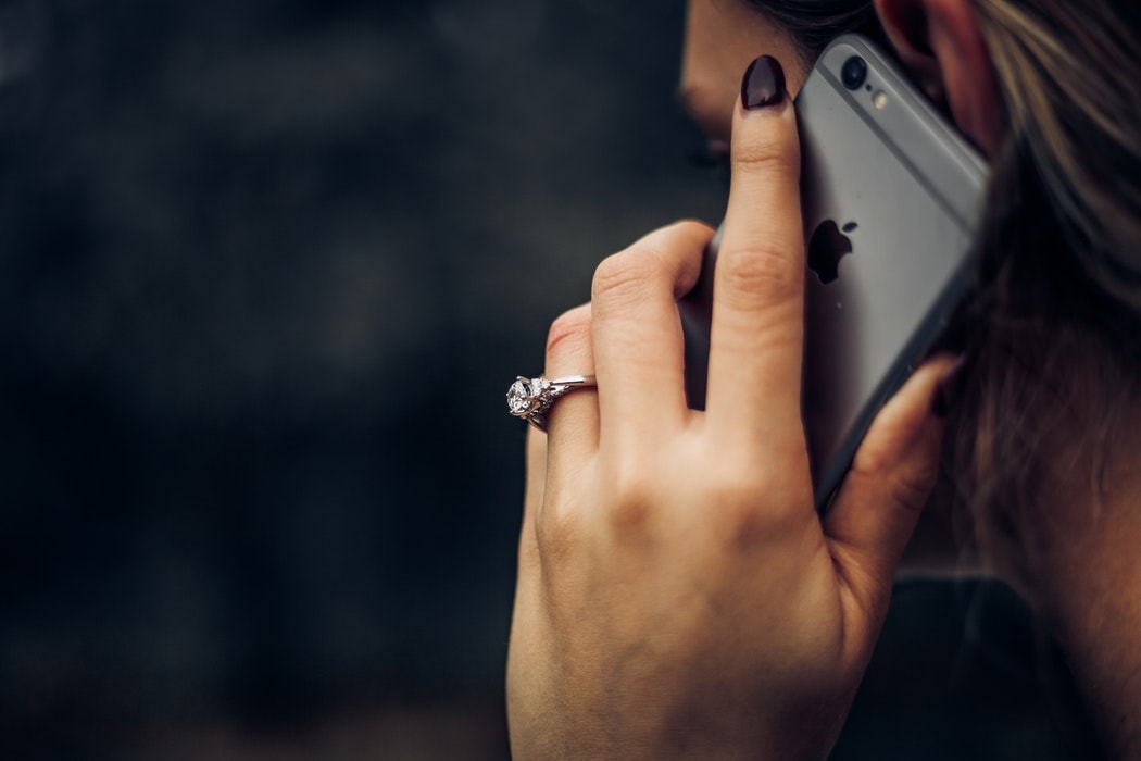 Girl with engagement ring holding phone