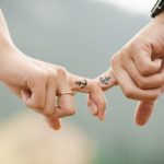Couple holding fingers with anchor tattoo