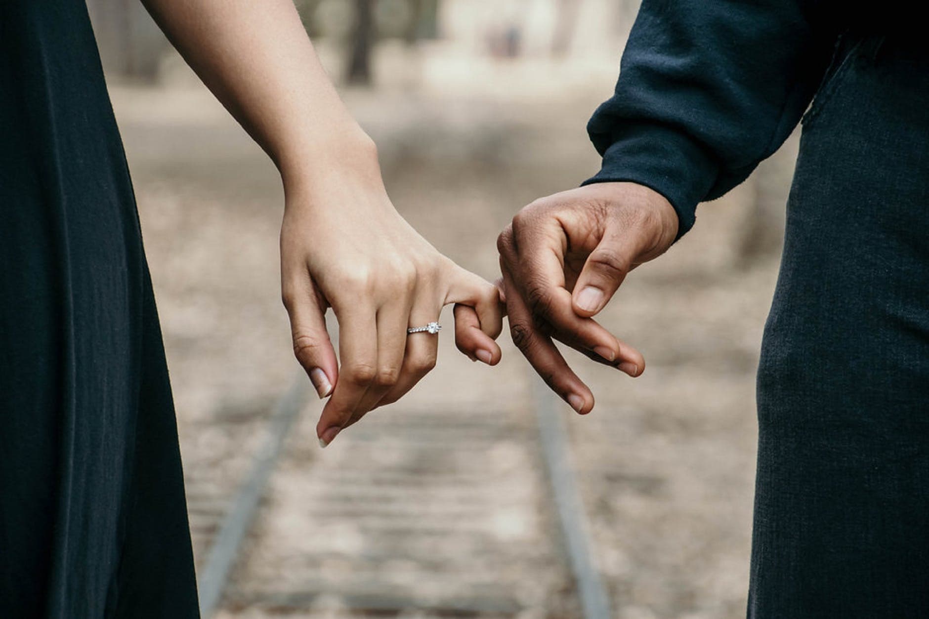 Couple holding hand, girl wearing engagement ring