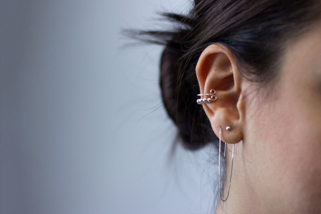 Girl with cartilage piercing ear closeup
