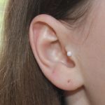 Opal stud om girl's ear