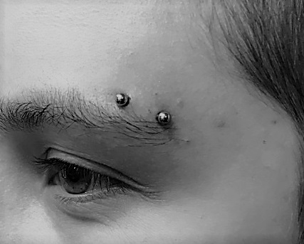 Girl with horizontal eyebrow piercing