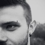 Man with vertical eyebrow piercing