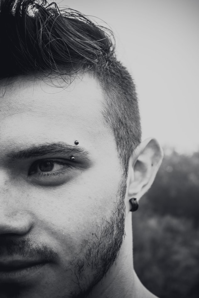 Man with vertical eyebrow piercing