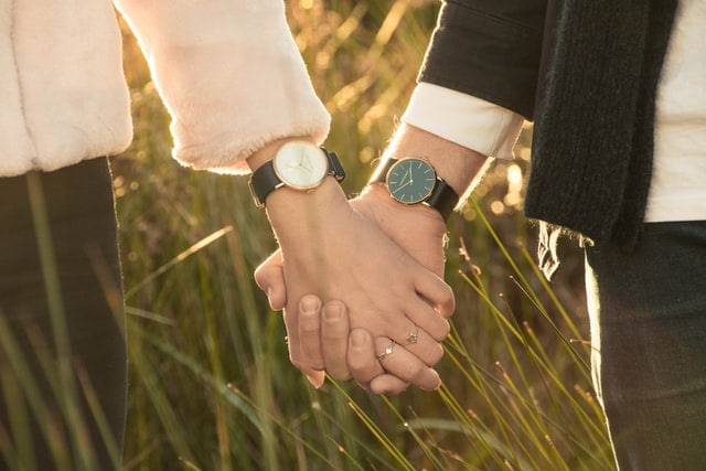 Couple wearing promise rings holding hands