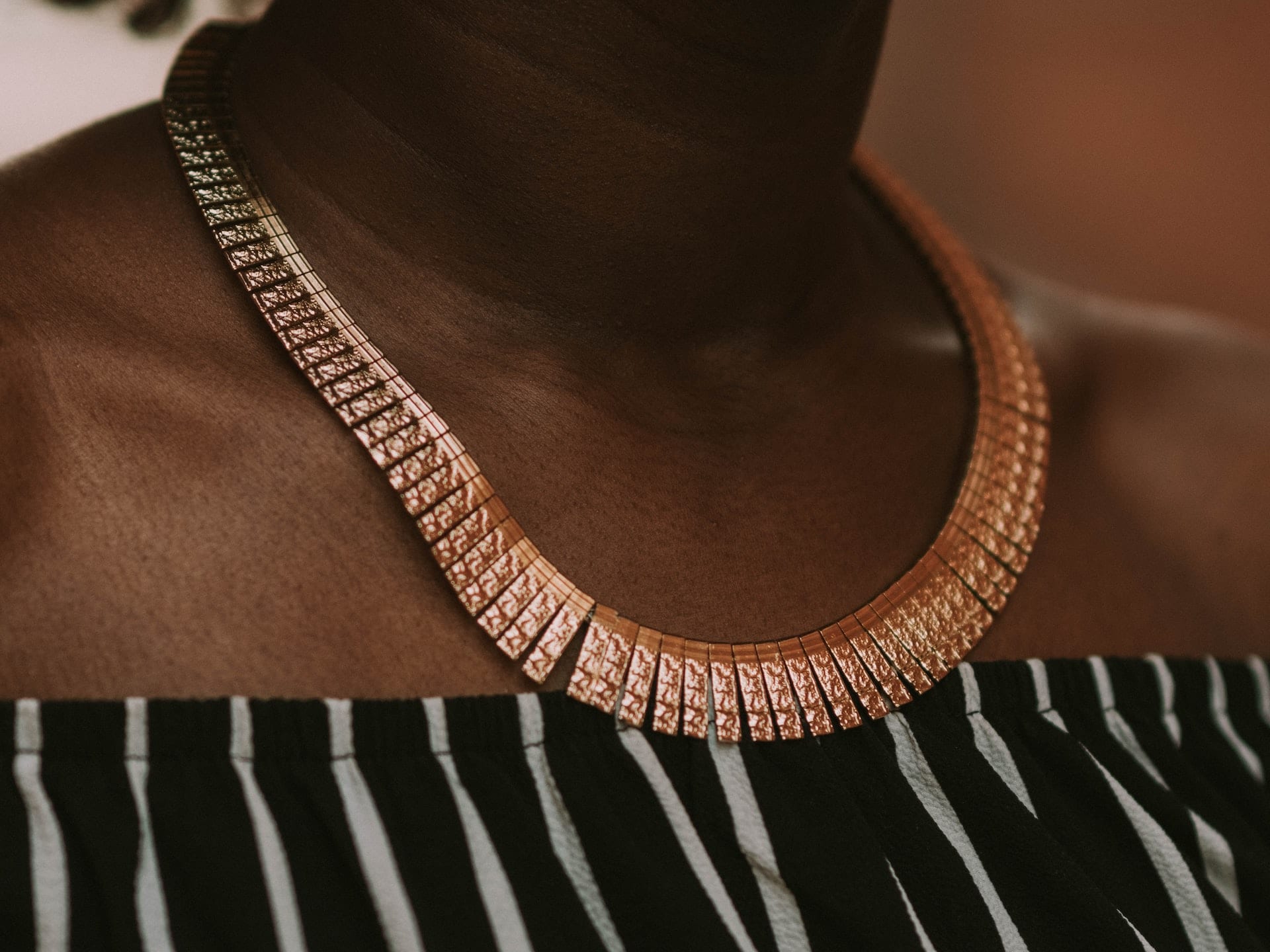 black woman with bronze copper statement necklace