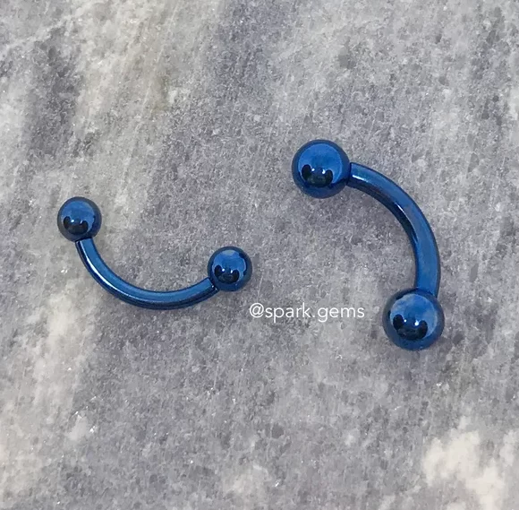 steel blue curved barbell bridge piercing