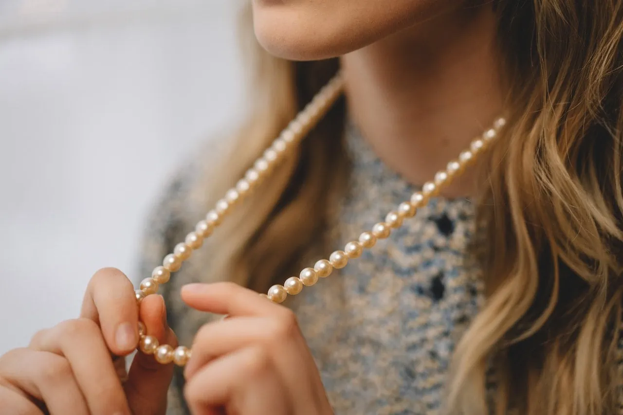 woman holding pearl necklace in hands