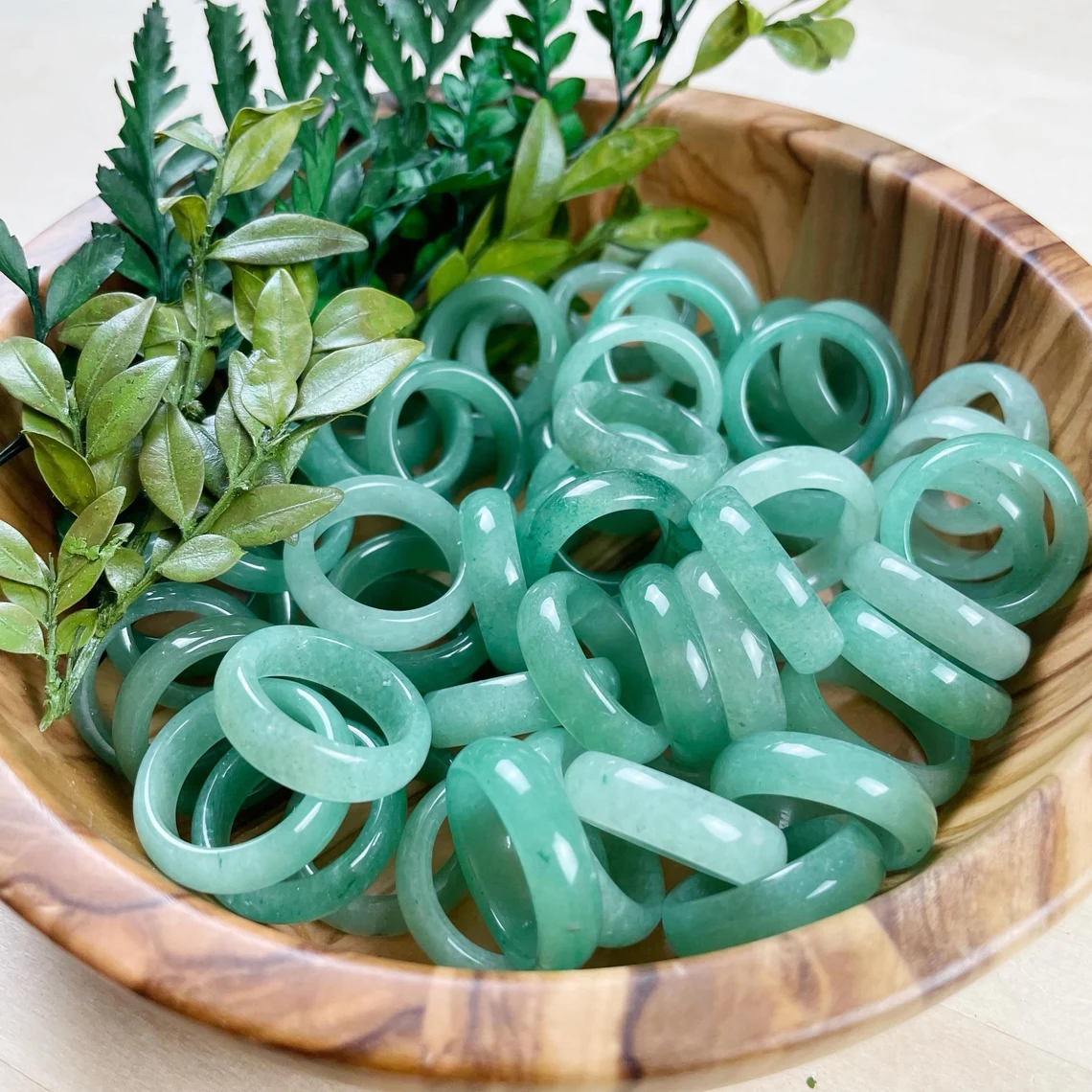 aventurine rings in wooden bowl