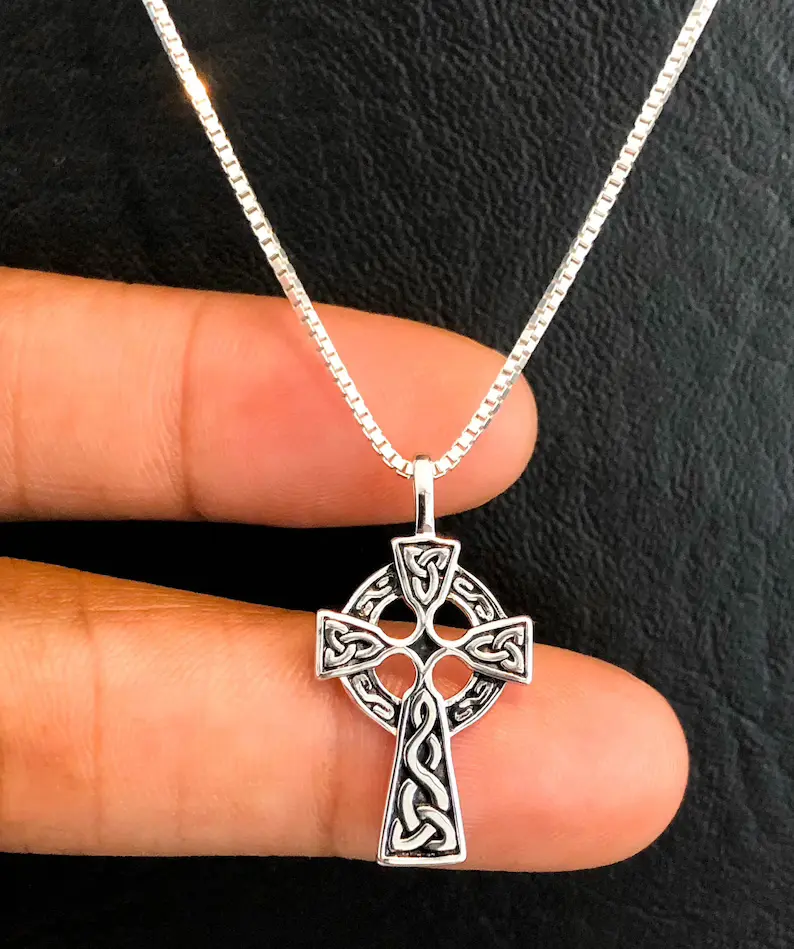 holding a celtic cross necklace