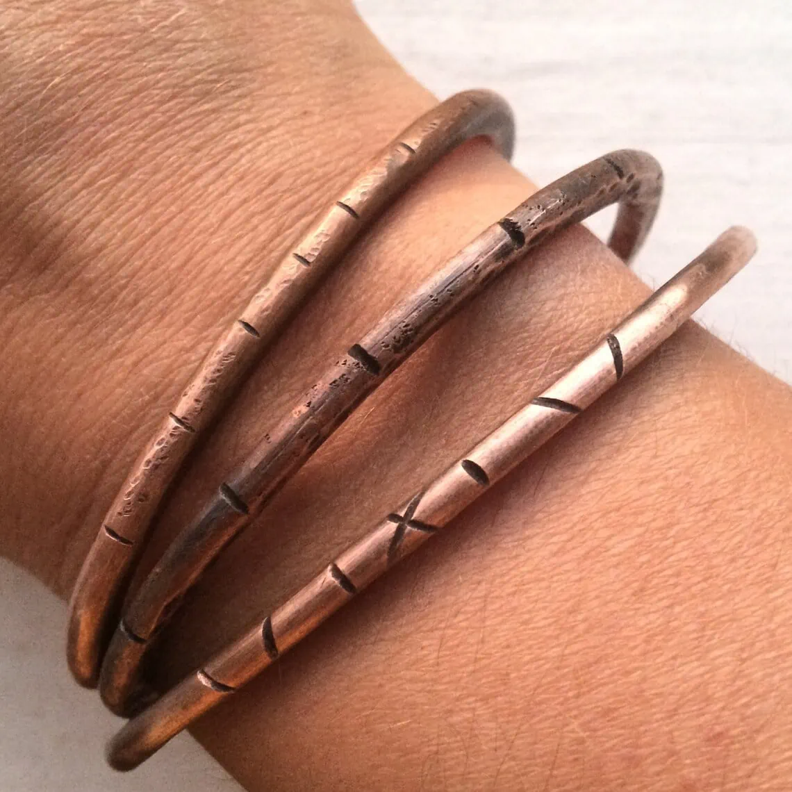 rustic copper bracelets on a wrist