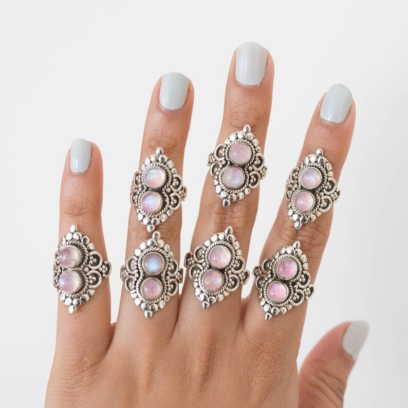 a hand with pink moonstone rings
