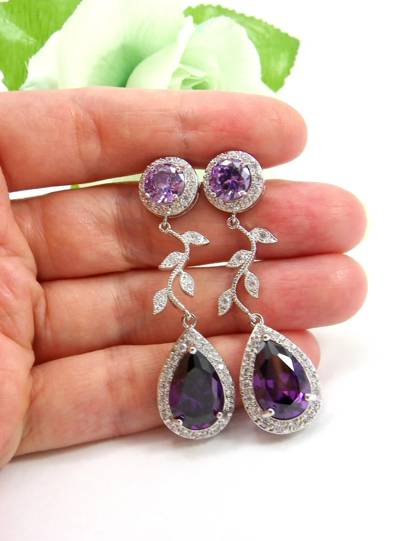 holding purple zircon earrings