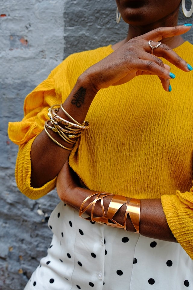 woman wearing different bracelets in one color