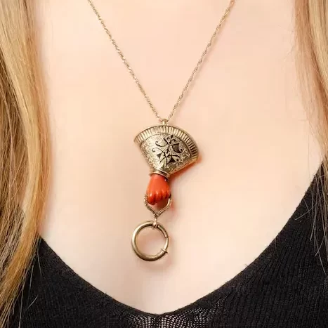 a woman wearing antique coral hand charm holder necklace