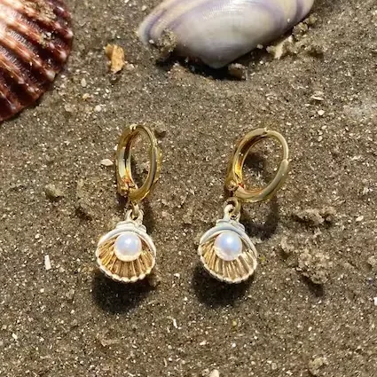 gold shell pearl hoop earrings on the sand