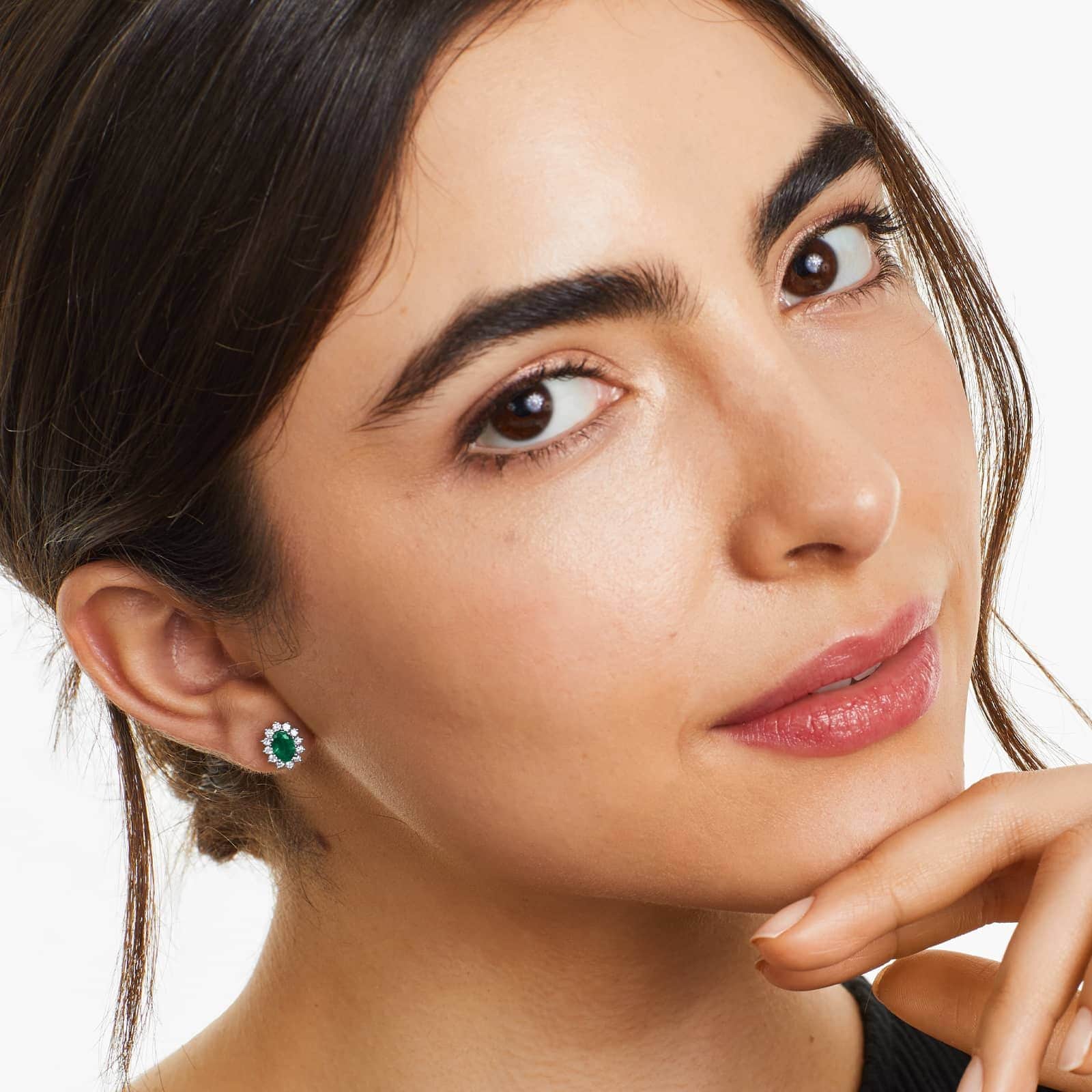 emerald earrings with diamond halo on a girl