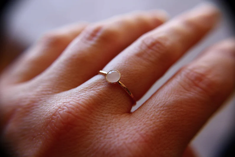 a hand with rose quartz stackable ring