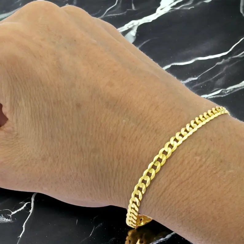 10k yellow gold curb link bracelet on a man's wrist