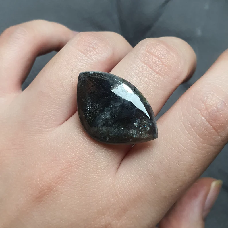 black diopside stone on top of the fingers