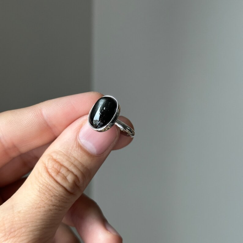 black star diopside ring in between fingers