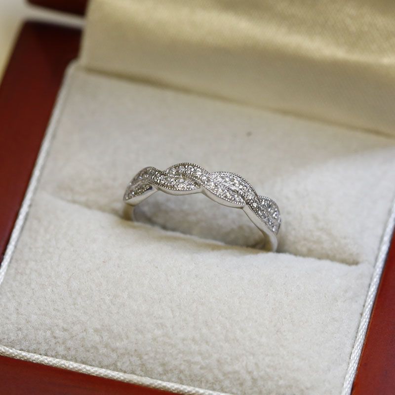 braided pave diamond wedding band in a red jewelry box