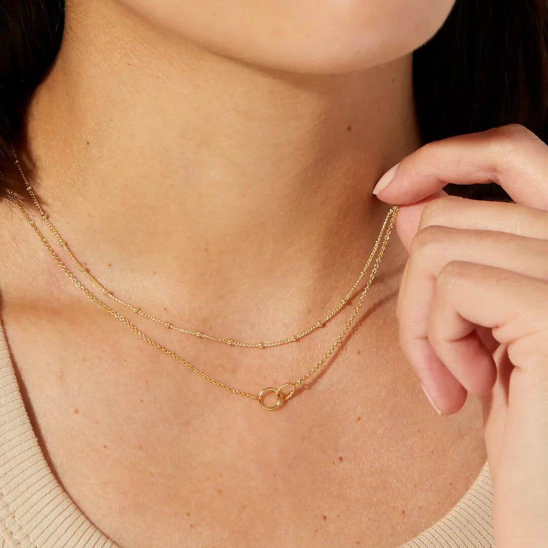 a woman wearing delicate necklace layers bundle