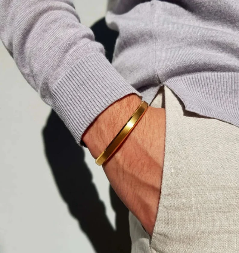 a man wearing a gold cuff bracelet