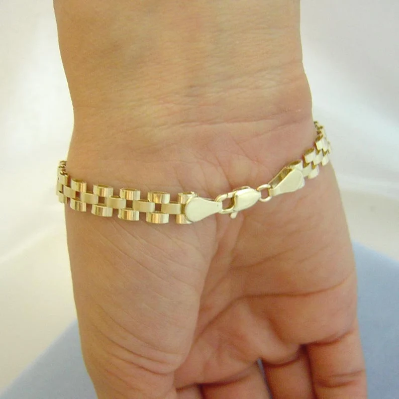 a wrist with gold watch band style bracelet