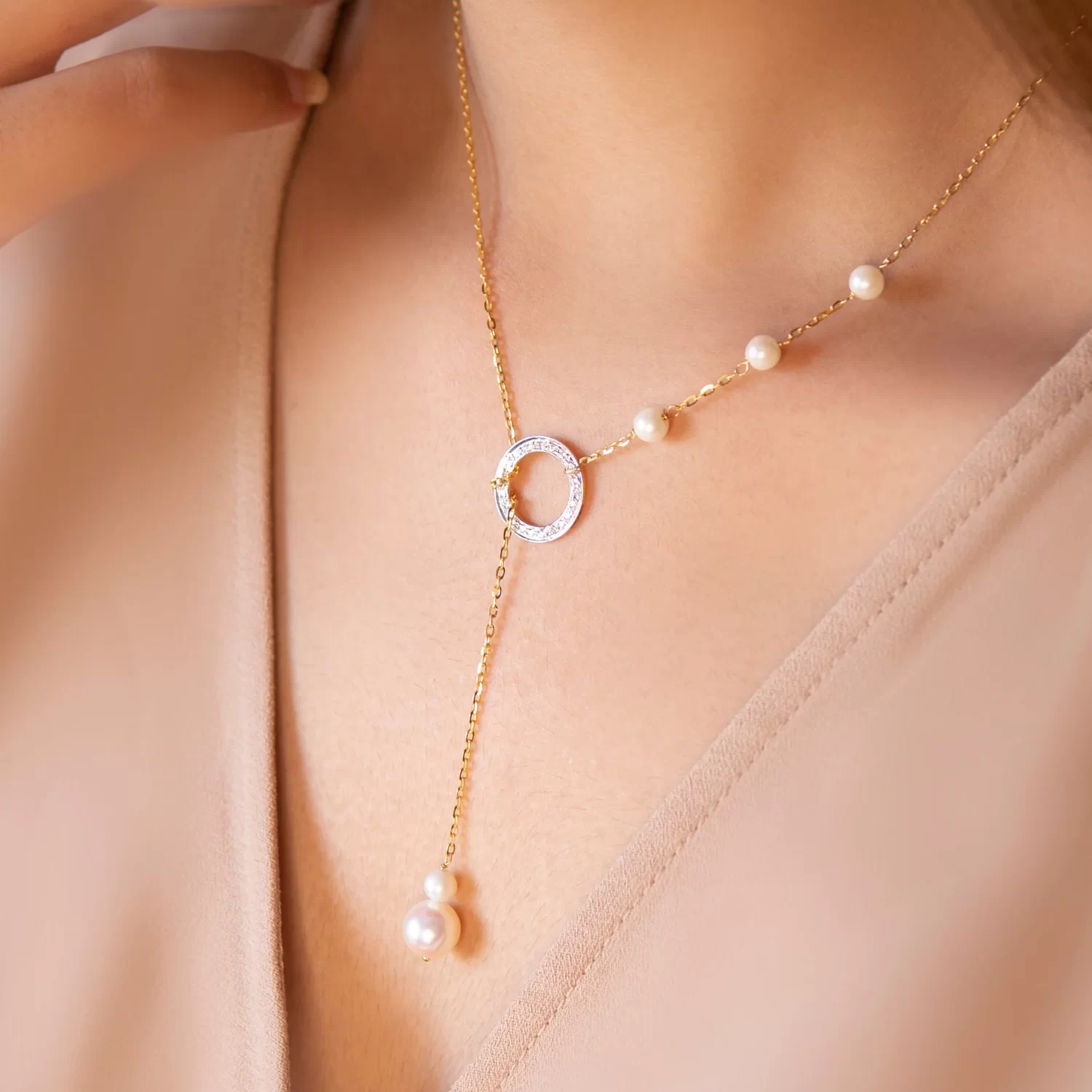 pearl circle lariat necklace on a woman's neck