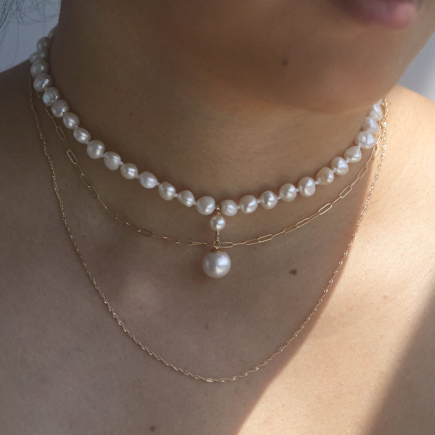 a woman wearing necklaces and princess buttercup pearl choker