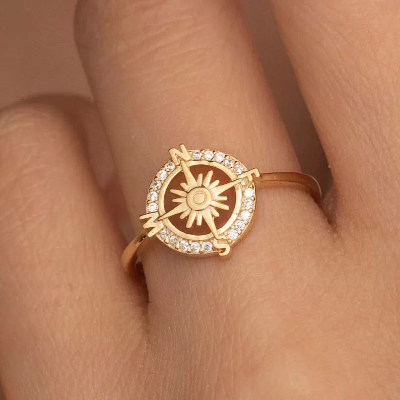 14k solid gold compass ring on a finger