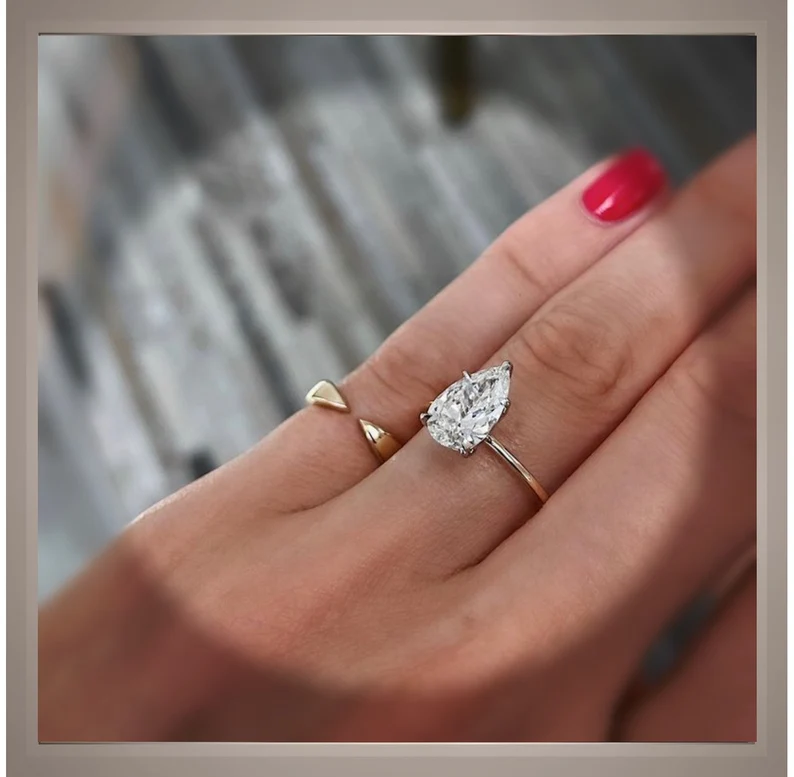 2 carat pear diamond engagement ring on a woman's finger