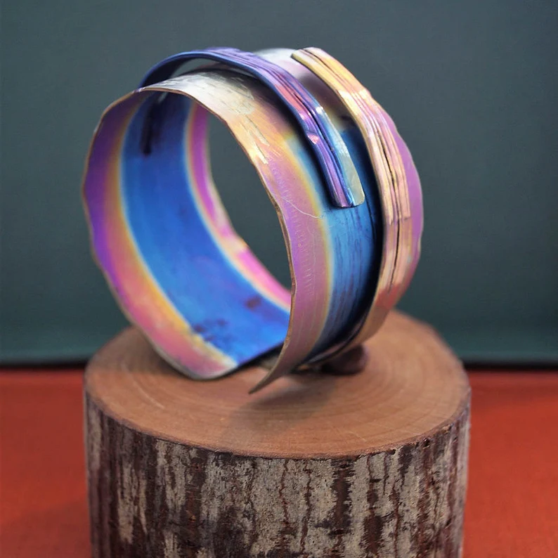 anodized titanium bracelet on top of a wood stand