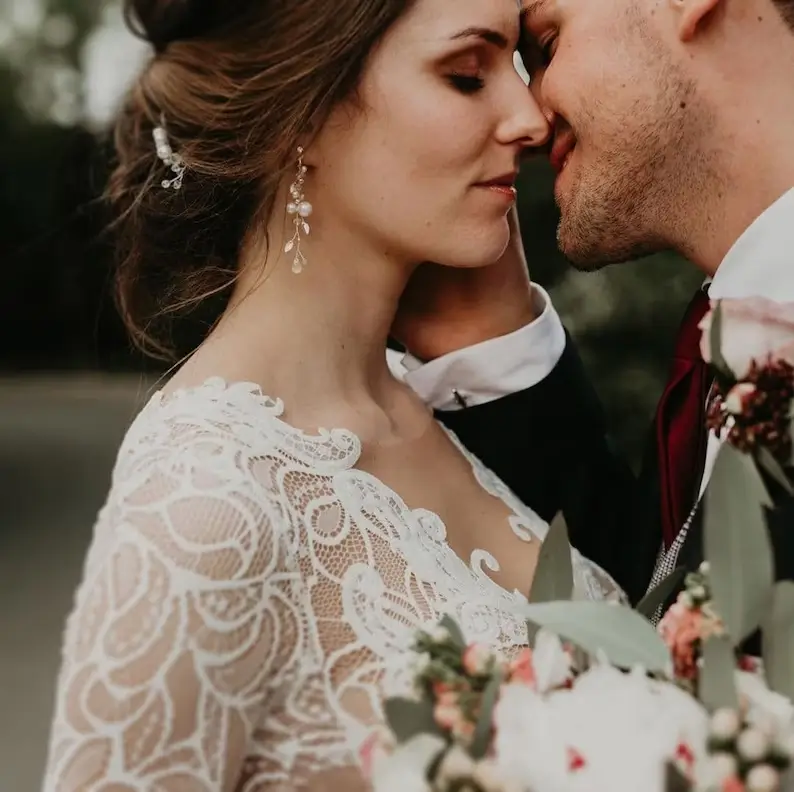 a groom with the bride wearing pearl jewelry