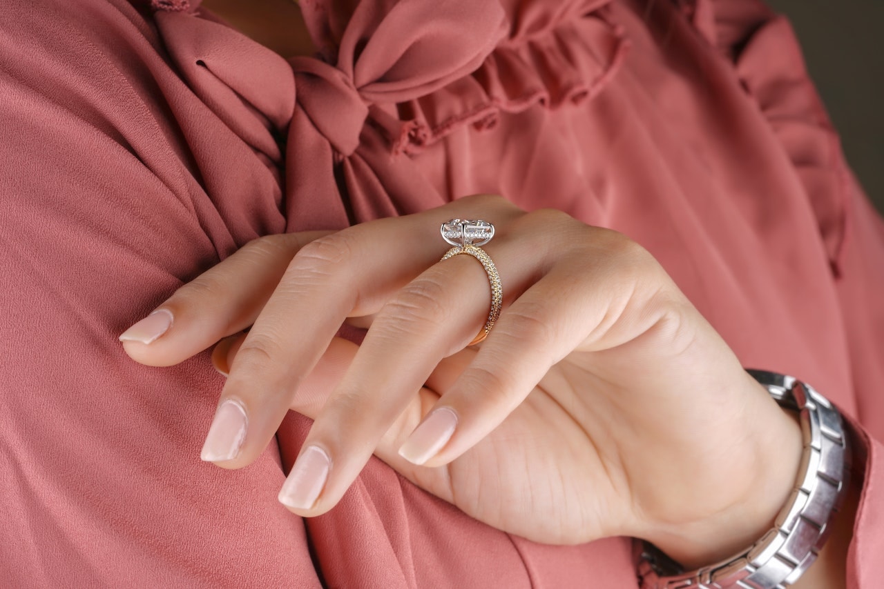 a woman wearing a gold diamond ring