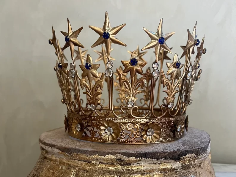 large antique crown on top of a brass stand