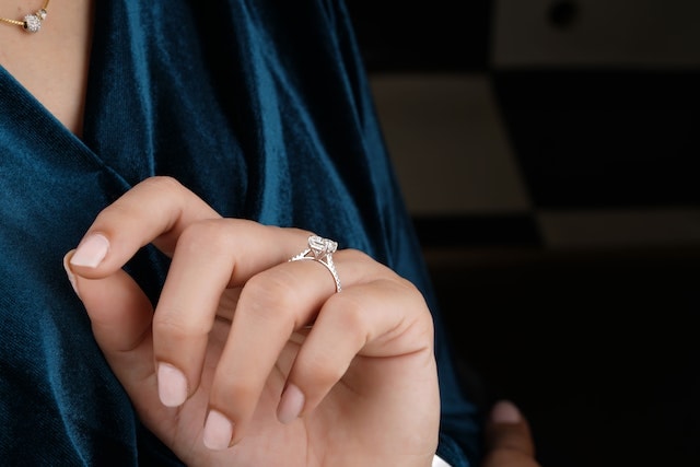a woman wearing a white gold diamond ring