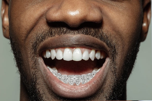 a man with 8 teeth full diamond grillz
