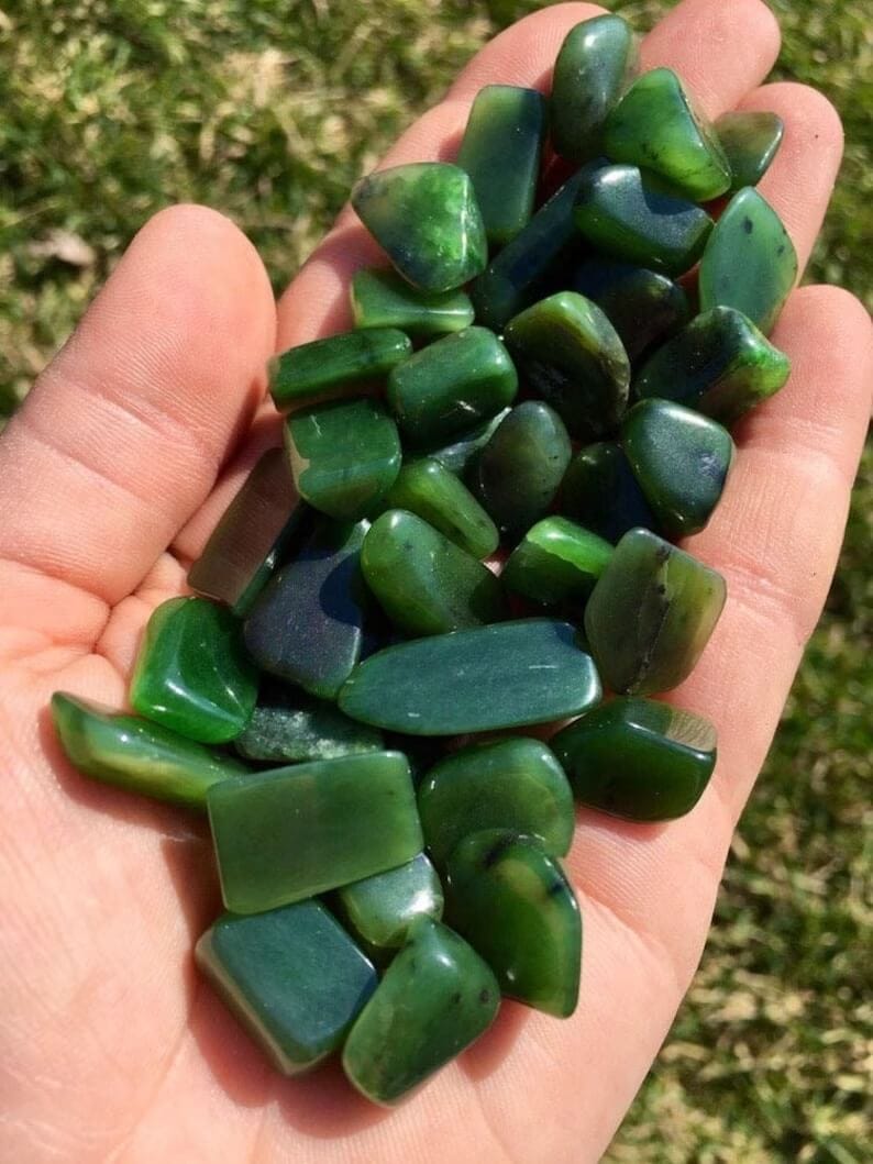 nephrite jade tumbled stones on a hand