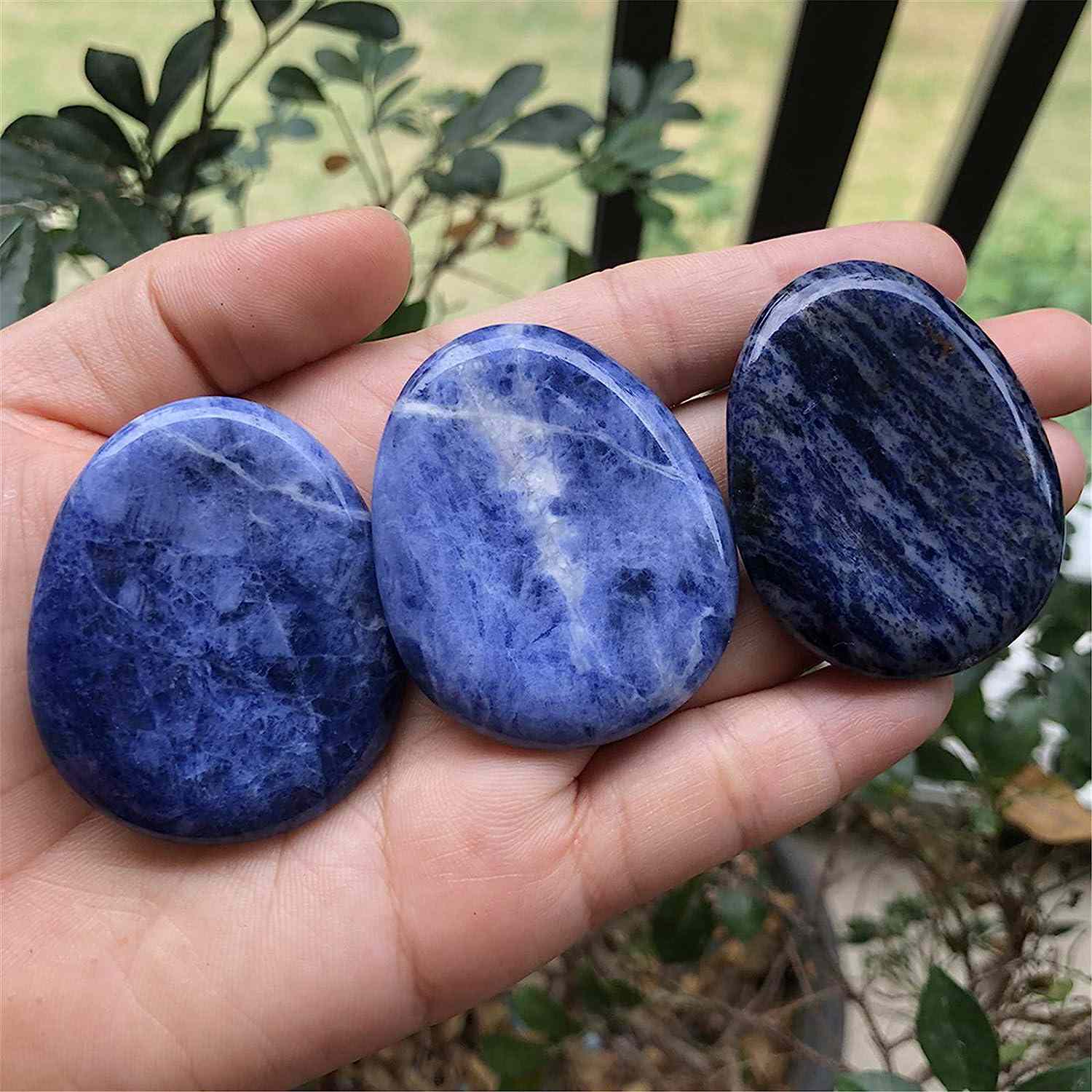 a hand with three pieces sodalite stones