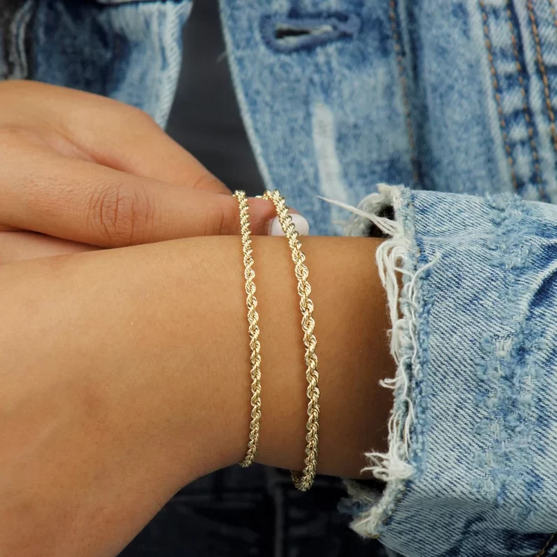 holding two 10k gold rope chain bracelets